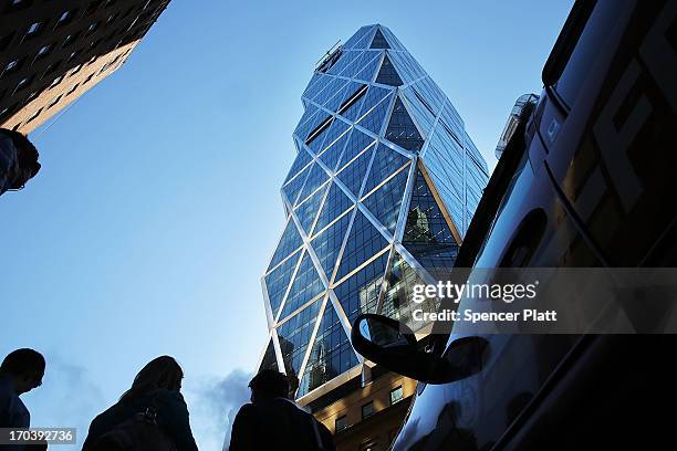 People stand below broken scaffolding on the top of the 46-story Hearst Tower after two trapped window washers were rescued on June 12, 2013 in New...