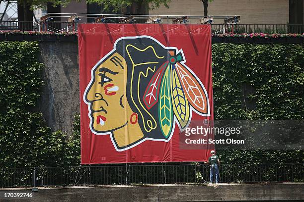 Worker adjusts a Chicago Blackhawks' banner alongside the Chicago River in the Loop on June 12, 2013 in Chicago, Illinois. The Chicago Blackhawks...