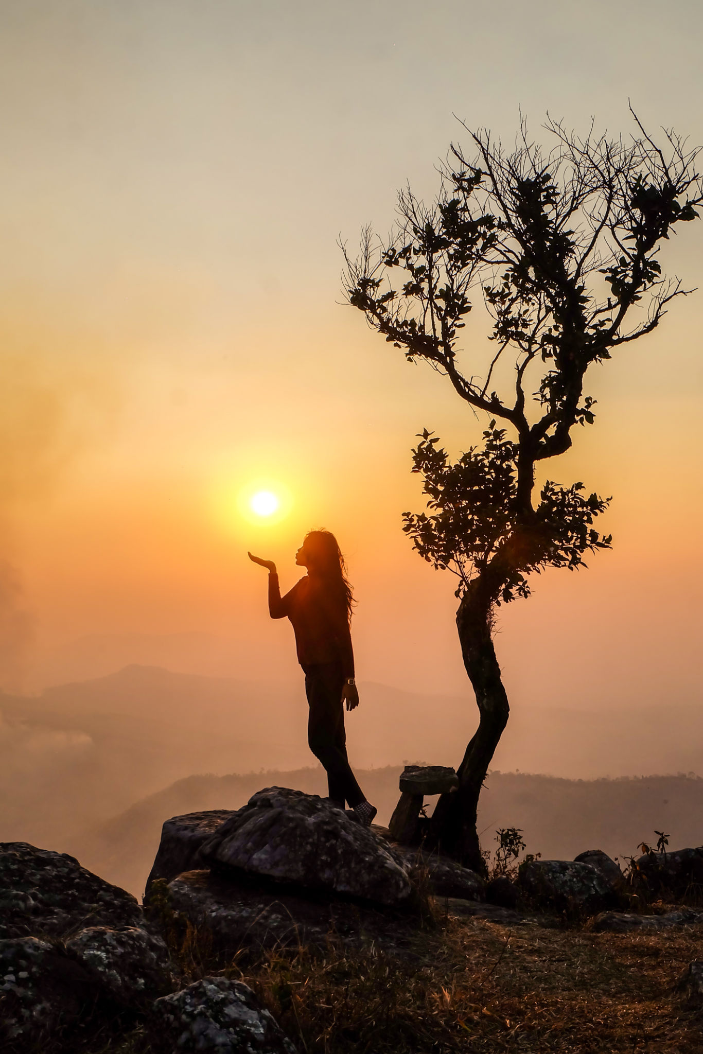 Backlight sunlight with beautiful on Top of a Peak. Tourists are sitting at the cliff of mountain to see scenic view of sunset. Evening sky and silhouette. Backlight sunlight with beautiful on Top of a Peak. Tourists are sitting at the cliff of mountain to see scenic view of sunset. Evening sky and silhouette.