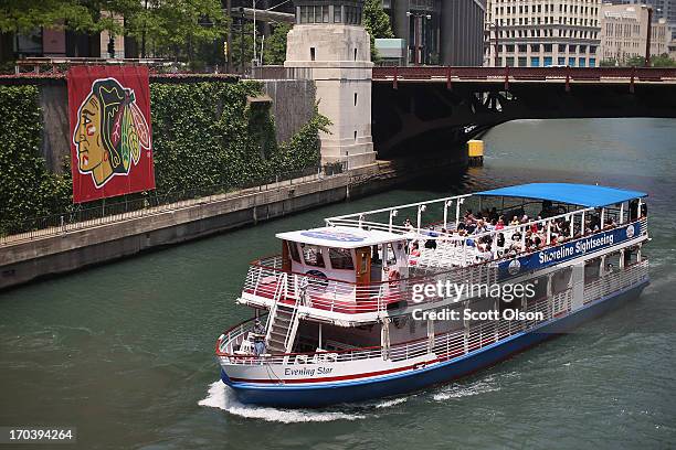 Tour boat passes by a Chicago Blackhawks' banner on the Chicago River in the Loop on June 12, 2013 in Chicago, Illinois. The Chicago Blackhawks will...