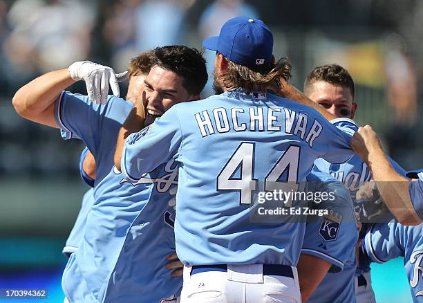 Eric Hosmer of the Kansas City Royals celebrates his game-winning RBI single with Luke Hochevar and teammates in the 10th inning during a game...