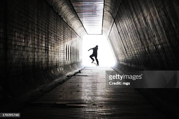 skateboarder at tunnel - indoor skating stock pictures, royalty-free photos & images