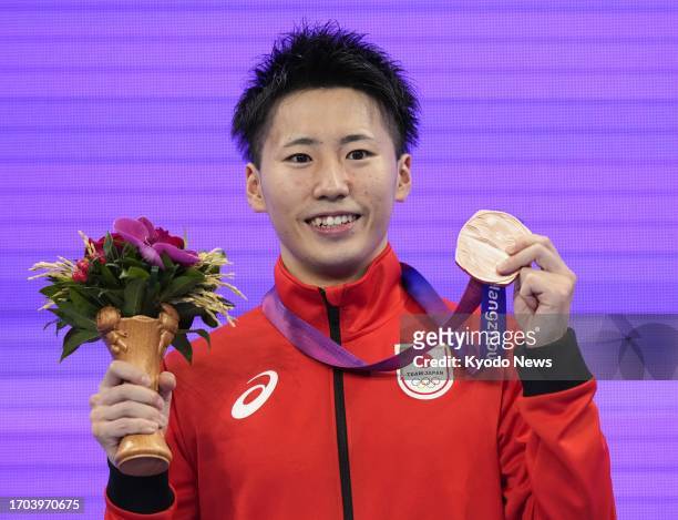 Japan's Hiroto Yamada poses with the bronze medal he won in the men's trampoline gymnastics event at the Asian Games in Hangzhou, China, on Oct. 3,...