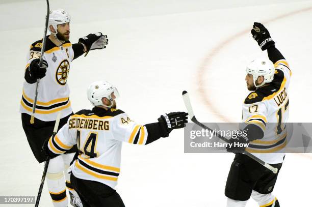 Zdeno Chara, Dennis Seidenberg and Milan Lucic of the Boston Bruins celebrate after Lucic scored a first period goal against the Chicago Blackhawks...