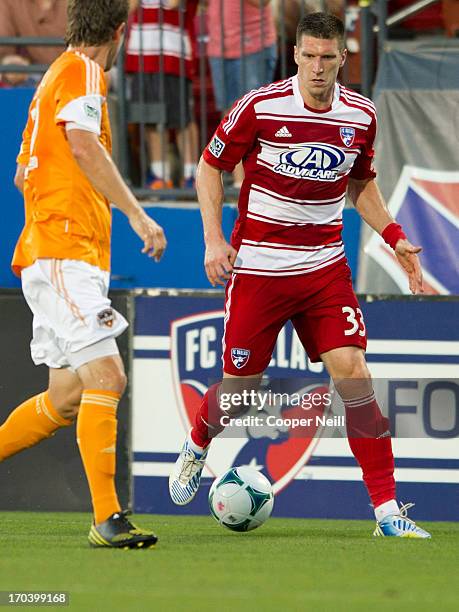 Kenny Cooper of FC Dallas brings the ball up field against Bobby Boswell of Houston Dynamo on June 12, 2013 at FC Dallas Stadium in Frisco, Texas.