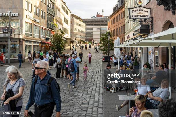Customers sit at terrace tables outside cafes in Nuremberg, Germany, on Monday, Oct. 2, 2023. German inflation plunged to its lowest level in two...