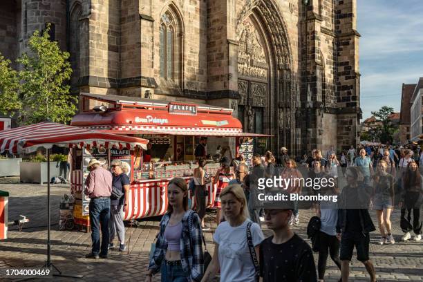 Shoppers pass a falafel food stall in Nuremberg, Germany, on Monday, Oct. 2, 2023. German inflation plunged to its lowest level in two years after...