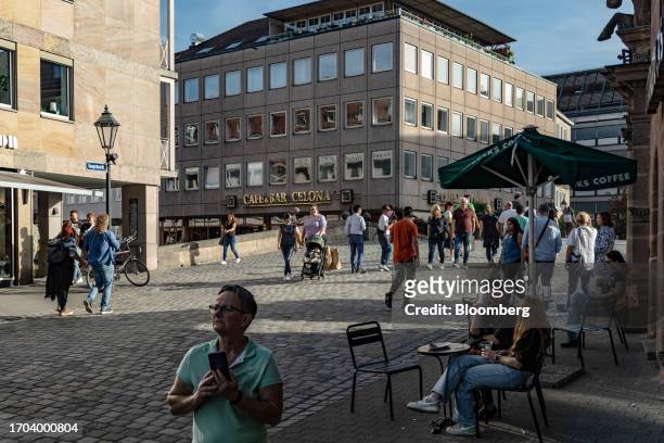 Customers sit at terrace tables outside a cafe in Nuremberg, Germany, on Monday, Oct. 2, 2023. German inflation plunged to its lowest level in two...