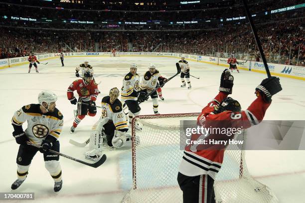 Michael Frolik of the Chicago Blackhawks celebrates after teammate Johnny Oduya scored a goal in the third period against goalie Tuukka Rask of the...