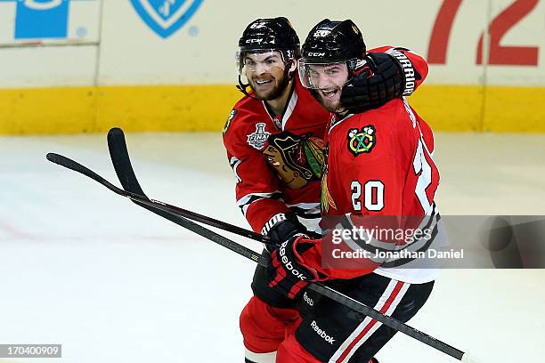 Michael Frolik and Brandon Saad of the Chicago Blackhawks celebrate after Johnny Oduya k scored a goal in the third period against the Boston Bruins...