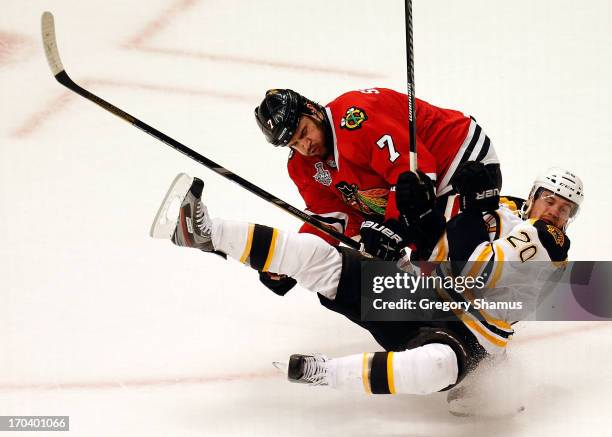 Brent Seabrook of the Chicago Blackhawks checks Daniel Paille of the Boston Bruins to the ice in Game One of the 2013 NHL Stanley Cup Final at United...