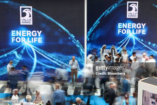 Attendees pass signage for Abu Dhabi National Oil Co. In the venue halls on day two of the Abu Dhabi International Petroleum Exhibition and...