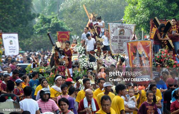 Philippino Catholics take part in a procession with replicas of the Black Nazarene, a life-size icon of Jesus Christ carrying a cross during the...