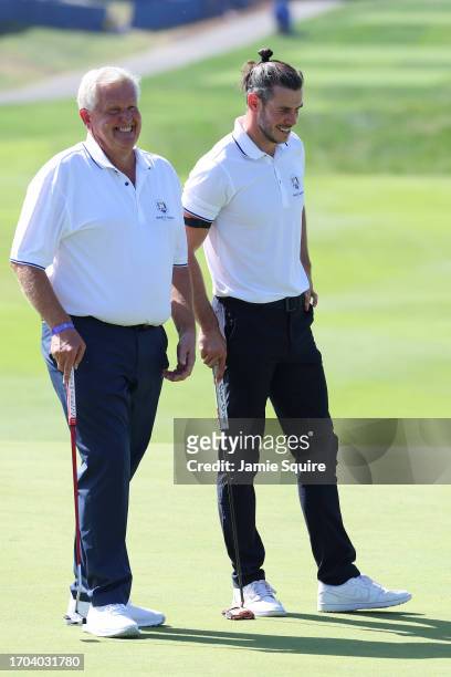 Former footballer, Gareth Bale and Colin Montgomerie of Scotland talk on the first green during the All-Star Match at the 2023 Ryder Cup at Marco...