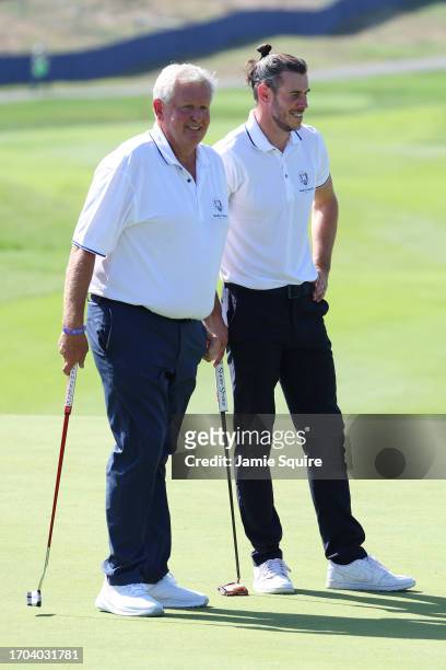 Former footballer, Gareth Bale and Colin Montgomerie of Scotland talk on the first green during the All-Star Match at the 2023 Ryder Cup at Marco...