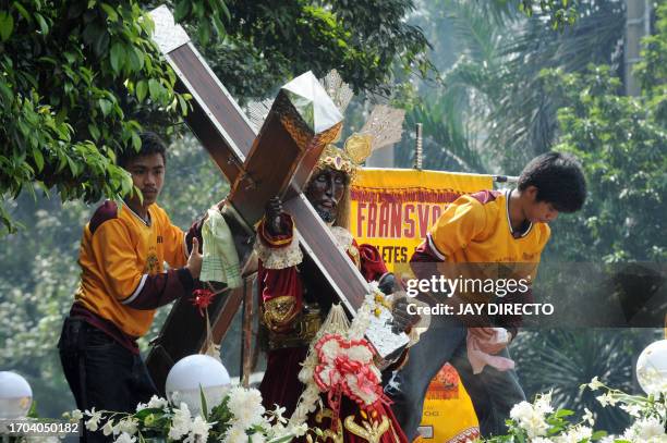 Philippino Catholics take part in a procession with replicas of the Black Nazarene, a life-size icon of Jesus Christ carrying a cross during the...