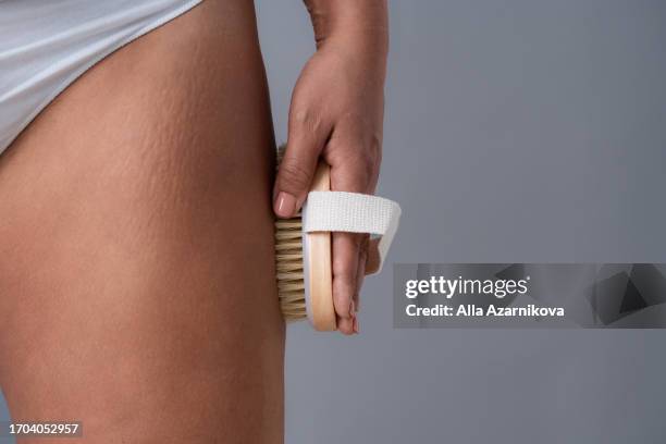 close up view of the woman making anti-cellulite massage with dry wooden cactus brush. organic treatment for peeling skin. body care concept - cellulite stock pictures, royalty-free photos & images