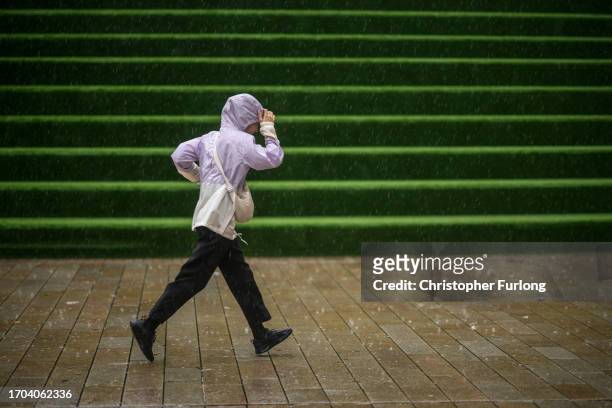 People brave the first rain and wind of Storm Agnes as it approaches the UK on September 27, 2023 in Liverpool, United Kingdom.