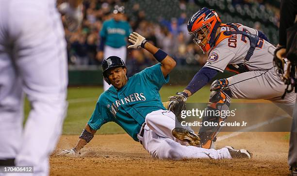 Endy Chavez of the Seattle Mariners scores on an RBI single by Nick Franklin against catcher Carlos Corporan of the Houston Astros in the eighth...