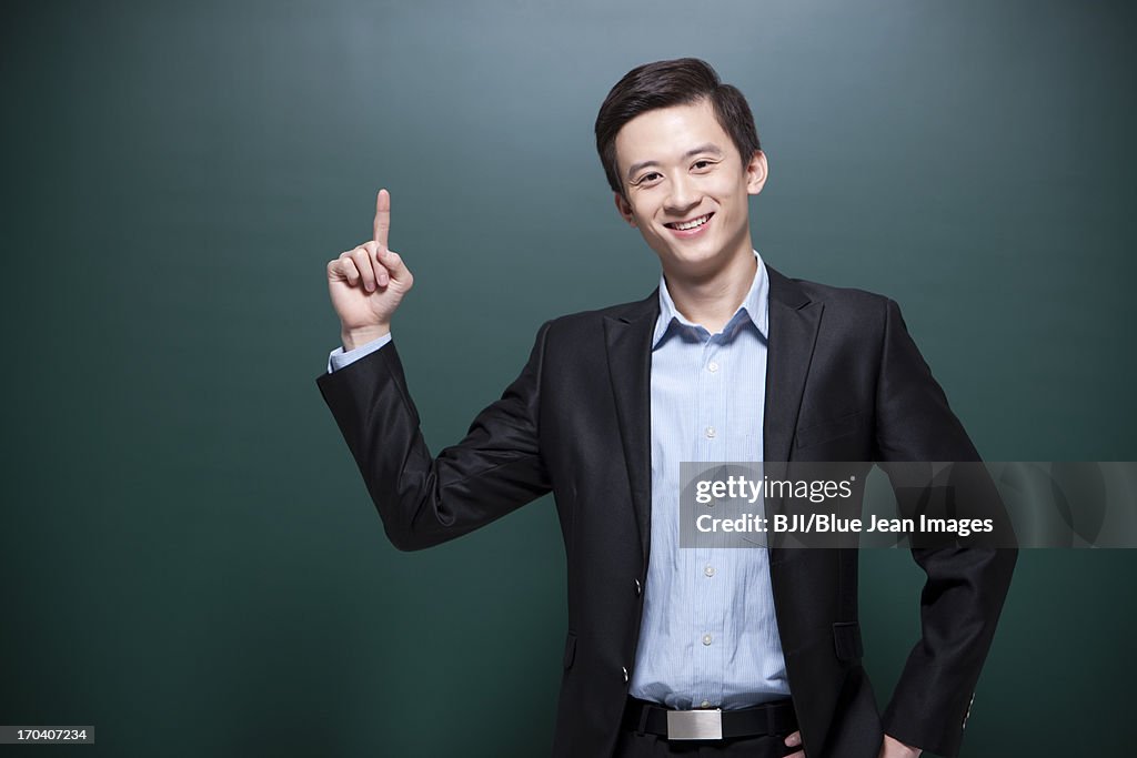 Happy male teacher raising finger up