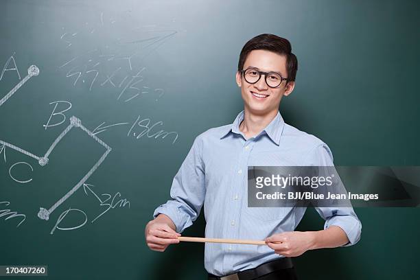 confident male teacher giving lessons in classroom - pointer stick stock pictures, royalty-free photos & images
