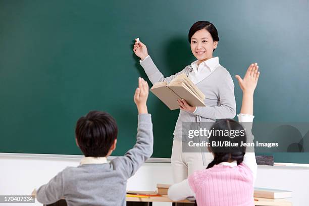schoolchildren and teacher in class - classroom-front-view stock-fotos und bilder