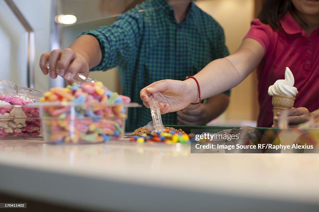 Children choosing toppings in store