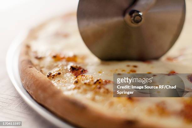 close up of cutter slicing pizza - ピザカッター ストックフォトと画像