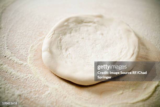 close up of pizza dough being flattened - dough stock-fotos und bilder