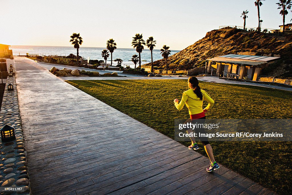 Woman running on wooden path