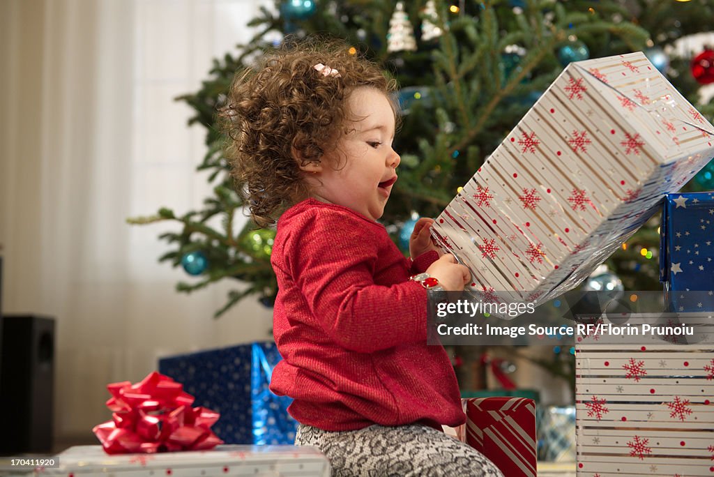 Toddler girl opening Christmas gifts