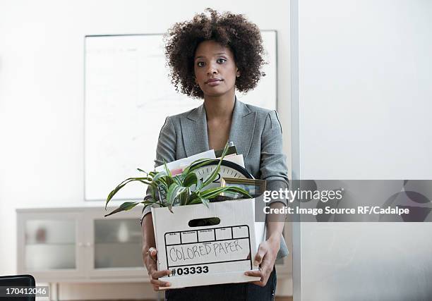 businesswoman packing up box in office - rauswerfen stock-fotos und bilder