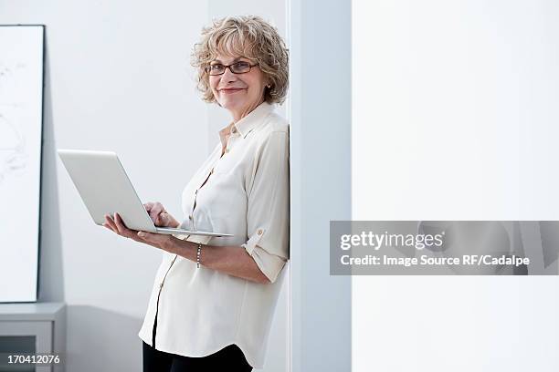 businesswoman using laptop in office - rf business stock-fotos und bilder