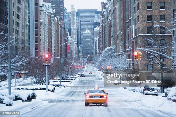 taxi on snowy city street - new york city snow stock pictures, royalty-free photos & images