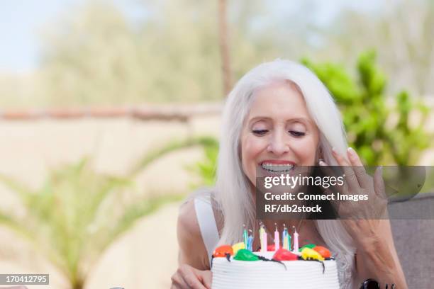 older woman blowing birthday candles - birthday cake 50 stock pictures, royalty-free photos & images