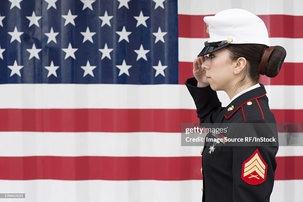 Servicewoman in dress blues by US flag