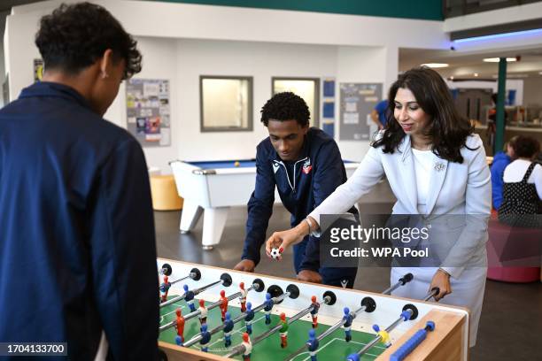 Britain's Home Secretary Suella Braverman plays table football during a visit to Bolton Lads and Girls Club on October 3, 2023 in Bolton, England.
