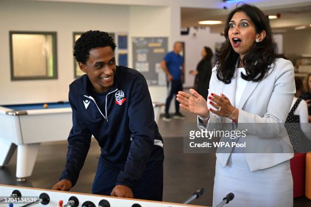 Britain's Home Secretary Suella Braverman reacts while playing table football during a visit to Bolton Lads and Girls Club on October 3, 2023 in...