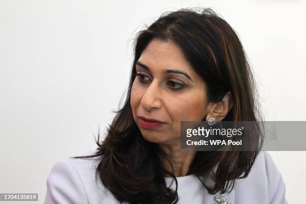 Britain's Home Secretary Suella Braverman speaks to volunteers during a visit to Bolton Lads and Girls Club on October 3, 2023 in Bolton, England.