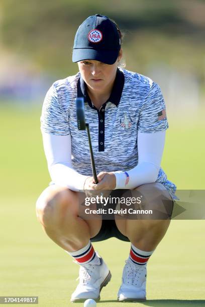 Ally Ewing of The United States team lines up a putt on the 14th hole in her match with Nelly Korda against Charley Hull and Leona Maguire during the...