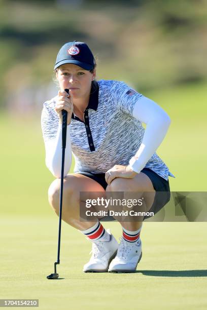 Ally Ewing of The United States team lines up a putt on the 14th hole in her match with Nelly Korda against Charley Hull and Leona Maguire during the...