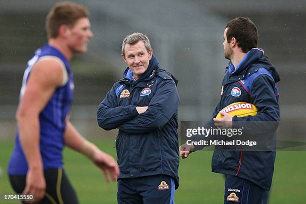 Coach Brendan McCartney reacts to assistant coach Matthew Scarlett during a Western Bulldogs AFL training session at Whitten Oval on June 13, 2013 in...