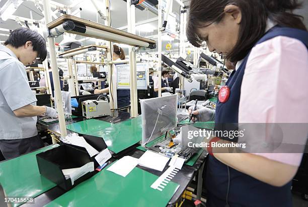 Workers assemble Panasonic Corp.'s Let's Note laptop computers on the production line at the company's plant in Kobe City, Hyogo Prefecture, Japan,...