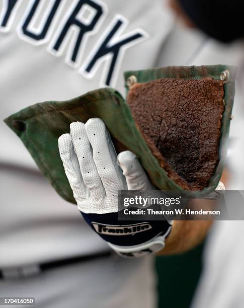 Kevin Youklis of the New York Yankees holds onto the wearing Franklin batting gloves holds onto the pinetar rag in the dugout against the Oakland...