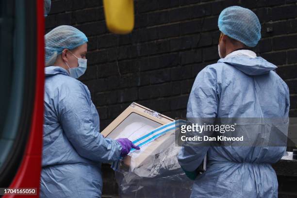 Police forensic officers remove a handwritten note as evidence from the scene of a fatal stabbing of a fifteen year old girl, behind the Whitgift...