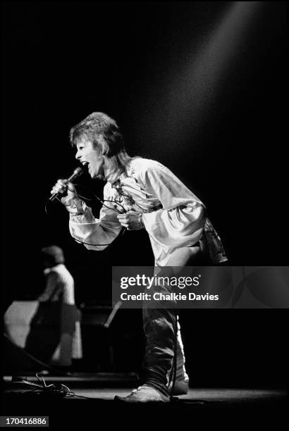 David Bowie performs on stage at Hammersmith Odeon on the last night of the Ziggy Stardust Tour, London, 3rd July 1973. At the end of the show David...