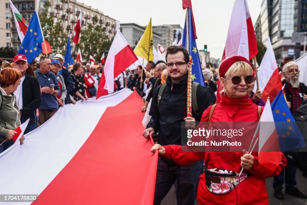 People hold flags while attending 'Million Hearts March' organized by Civic Coalition in Warsaw, Poland on October 1st, 2023. The largest...