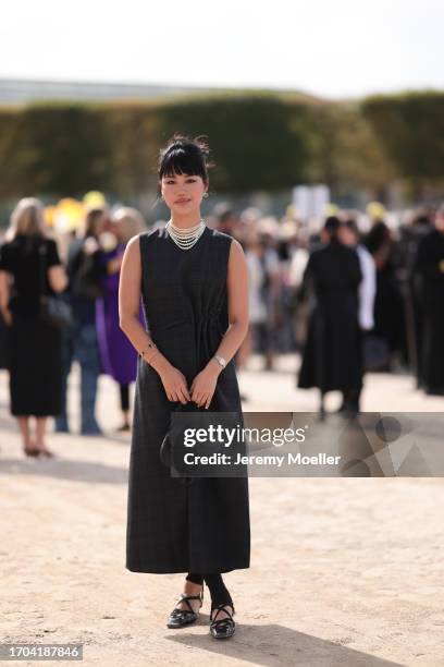 Jihoon Kim is seen outside Dior show wearing crystal Dior earrings, layered pearl necklace, grey Dior dress with folded waist, black Dior Saddle...