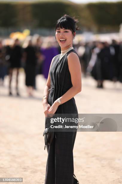 Jihoon Kim is seen outside Dior show wearing crystal Dior earrings, layered pearl necklace, grey Dior dress with folded waist, black Dior Saddle...