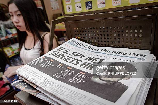 Woman walks past an edition of the South China Morning Post carrying the story of former US spy Edward Snowden on its front page in Hong Kong on June...